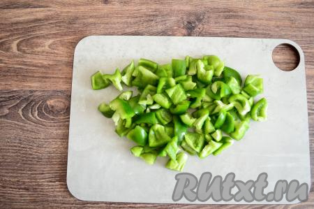 Из каждого болгарского перца удалить плодоножки с семенами. Промыть перцы водой, нарезать их на крупные кубики.