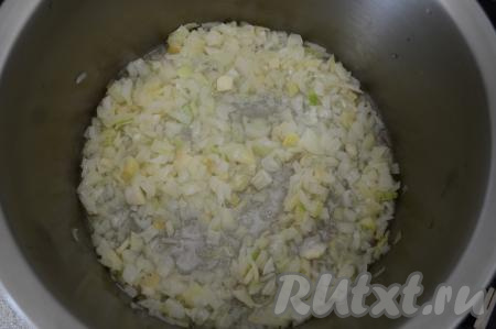 Пока отваривается рис, начинаем обжаривать овощи. Очищенный лук нужно нарезать на небольшие кубики. В кастрюлю с толстым дном объёмом не менее 4,5 литров влить 100 миллилитров растительного масла, выложить нарезанный лук, обжарить его на среднем огне до прозрачности (в течение 5-6 минут). Я готовила всю заготовку сразу в кастрюле, это очень удобно. Но чтобы готовить в кастрюле, она должна быть с толстым дном (эмалированная кастрюля не подойдёт, так как в ней блюдо может подгореть). Если у вас нет кастрюли с толстым дном, тогда обжаривайте овощи в сковороде, а затем тушите их в кастрюле.