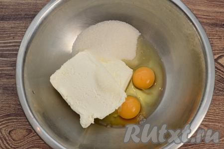В миску выложить творог, всыпать сахар, добавить сырые яйца.