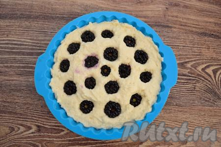 Затем равномерно распределить ягоды по поверхности будущей запеканки, немного утапливая ежевику, но не до конца.