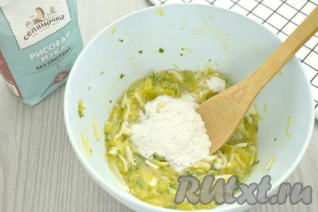 В получившуюся массу из кабачка и сыра начинаем по 1 столовой ложке всыпать рисовую муку, каждый раз тщательно перемешивая и контролируя густоту замешиваемого теста. 