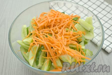 Очищенную морковь натираем на тёрке для корейской моркови (если нет такой тёрки, можно натереть морковку на крупной тёрке), выкладываем к огурцам.
