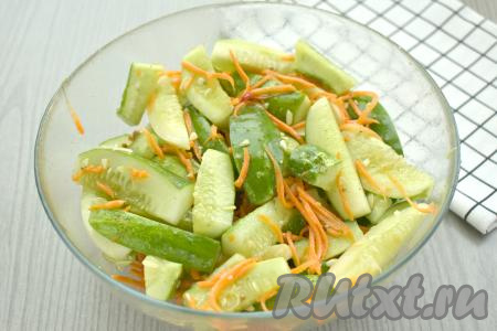 Вливаем растительное масло, хорошо перемешиваем огурцы с морковкой, чесноком и специями.