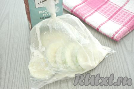 В пакет с мукой выкладываем кружочки кабачка (при желании можно выкладывать не все кабачки, а столько, сколько у вас за раз поместится на сковороде).