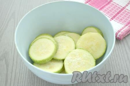 Перекладываем кружочки кабачков в миску, посыпаем солью, перемешиваем и оставляем на 5 минут, чтобы из кабачков выделился сок. По прошествии 5 минут сок, выделившийся из кабачков, выливаем (этот сок нам не понадобится).