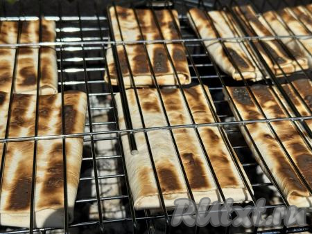 Поместить решётку с конвертиками на мангал с раскалёнными углями, прямого огня быть не должно. Жарить лаваш с творогом и сыром в течение 5 минут (до подрумянивания с двух сторон), используя жар от углей, часто переворачивая решётку. Время приготовления во многом зависит от жара мангала.&nbsp;