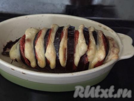 На дно формы влить немного воды. Поставить форму с баклажаном "Гармошка" с помидорами и сыром в духовку, разогретую до 200 градусов, на 40 минут. По желанию перед запеканием можно прикрыть форму фольгой. Готовый баклажан должен стать достаточно мягким, легко прокалываться зубочисткой.