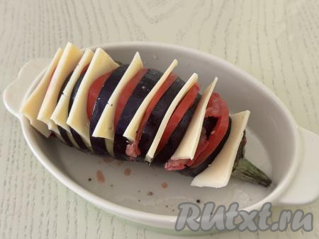 Помидоры нарезать на тонкие кружочки, сыр - на тонкие пластинки. В каждый надрез баклажана вставить по пластинке сыра и по кружочку помидора.&nbsp;