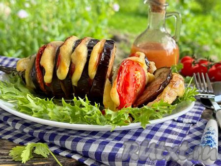 Готовую гармошку из баклажана достать из духовки, переложить на тарелку и подать к столу в горячем виде. Благодаря помидорам и сыру, баклажан получается аппетитным, сочным и очень вкусным.