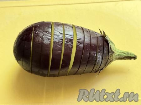 На поверхности баклажана сделать надрезы&nbsp;на расстоянии 5 миллиметров друг от друга, не прорезая баклажан до конца. Получится баклажан, напоминающий гармошку, как на фото.