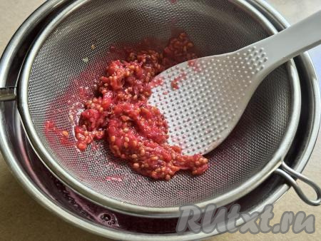 Теперь нужно отделить проваренную ягодную массу от косточек. Для этого нужно взять достаточно глубокую миску, поверх неё поставить сито. Выложить в сито проварившиеся ягоды красной смородины вместе с водой, в которой они варились. Лопаткой (или столовой ложкой) протереть смородину через сито в миску. В миске у нас будет находиться протёртая смородина без косточек. Практически сухой жмых, который останется в сите, нам не потребуется.&nbsp;