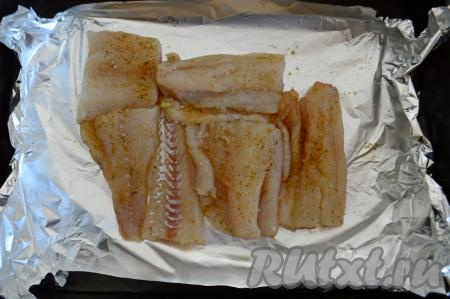 Форму для запекания застелить фольгой. Разложить на фольге кусочки филе минтая плотно к друг другу.