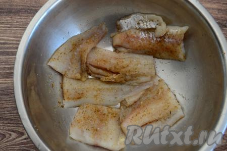 Посолить рыбу, добавить специи по вкусу (я использовала специи для рыбы). Перемешать, покрывая минтая специями со всех сторон.