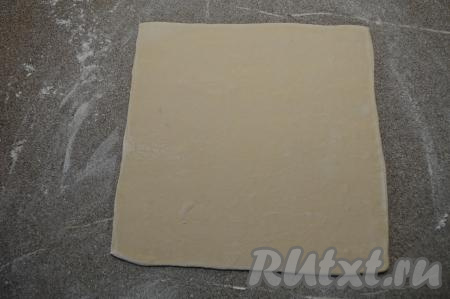 Пласт слоёного теста на слегка припылённой мукой поверхности раскатать в квадрат со стороной 23-24 сантиметра. Толщина раскатки примерно 3 миллиметра.&nbsp;