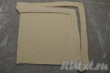 Взять получившуюся полоску теста с одного угла, перекинуть на противоположный угол квадрата, выложить сверху на тесто, сформировав бортик, слегка прижать полоску к тесту.