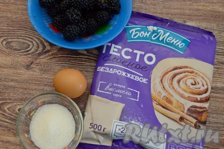 Подготовить продукты для приготовления пирога с ежевикой из слоёного теста. Слоёное тесто (отлично подойдёт и бездрожжевое, и дрожжевое слоёное тесто) разморозить при комнатной температуре, оно должно стать достаточно мягким. Этот пирог можно готовить как со свежей ежевикой, так и с замороженной. Свежую ежевику нужно будет промыть водой, обсушить ягоды, разложив их на бумажном полотенце или оставив в сите на несколько минут, чтобы стекла вода. Замороженную ежевику нужно разморозить, лишнюю жидкость слить.