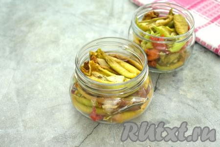 Вяленый перец раскладываем по простерилизованным баночкам, прикрываем прокипячёнными крышками. Мне потребовались 2 банки объёмом по 250 миллилитров каждая. Баночки я заранее простерилизовала в течение 5 минут над паром, а крышки к ним прокипятила в течение 3 минут с момента закипания воды.