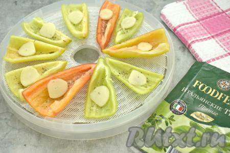 Очищаем зубчики чеснока, нарезаем на пластинки. Каждый кусочек перца посыпаем немного солью и специями (в качестве специй я использовала итальянские (прованские) сушёные травы). Выкладываем на каждый перец по пластинке чеснока.