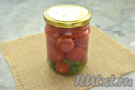 Прикрываем банки с помидорами в кипятке прокипячёнными крышками и оставляем на 15 минут. Затем воду из банок сливаем в кастрюльку так, чтобы черри остались в баночках. Удобно сливать воду из банок с помидорами, надев на баночки капроновые крышки с отверстиями. Банки с помидорами без жидкости прикрываем прокипячёнными крышками. Кастрюлю с водой, слитой из банок, ставим на сильный огонь, доводим до кипения. Закипевшую воду разливаем по банкам с черри, снова прикрываем крышками, в этот раз оставляем постоять на 10 минут.