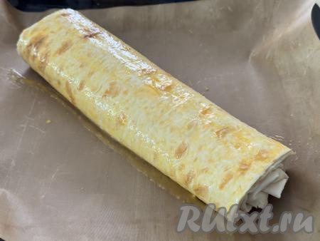 Отложенный ранее яичный желток взбить вилкой до однородности. Рулет из лаваша смазать сверху взбитым желтком.&nbsp;