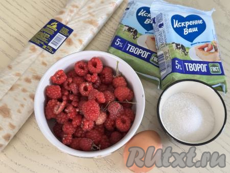 Подготовить продукты для приготовления рулета из лаваша с творогом и малиной в духовке. Творог можно купить любой жирности (я использовала жирностью 5%) и консистенции. Малину можно использовать как свежую, так и замороженную. Свежую малину нужно перебрать, убирая плодоножки, затем аккуратно промыть ягоды водой, разложить их на бумажном полотенце, чтобы они обсохли. Если же вы будете готовить рулет из лаваша с замороженной малиной, на которой нет большого количества наледи, значит ягоды можно не размораживать. 
