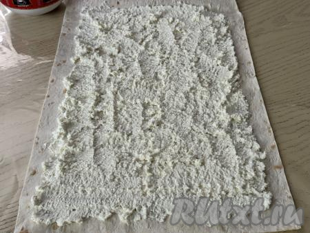 Отступая от краёв лаваша по 2 сантиметра, смазать равномерно лаваш творожной начинкой.&nbsp;