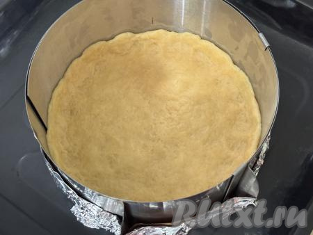 Взять разъёмную форму для выпечки диаметром 20 сантиметров (вместо формы я использовала разъёмное кольцо диаметром 20 сантиметров, сформировав дно из пергамента и фольги, сложенной в несколько слоёв). Достать тесто из холодильника, равномерно распределить его по дну форму, сформировав бортик высотой примерно 1 сантиметр.&nbsp;&nbsp;