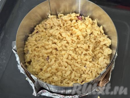 Достать вторую часть теста из морозилки, натереть его на крупной тёрке. Натёртое тесто равномерно распределить поверх ягод.&nbsp;