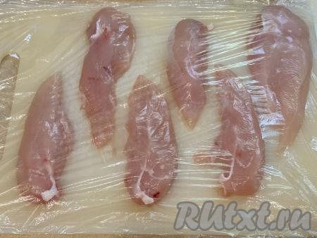 Куриное филе нарезать на полоски толщиной 1-1,5 сантиметра. У меня получились 6 полосок. Выложить нарезанное филе на разделочную доску, прикрыть пищевой плёнкой (или целлофановым пакетом).&nbsp;