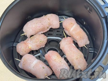 Выложить сформированные куриные рулетики с начинкой из сыра на решётку аэрогриля, крышку закрыть.