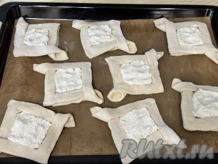 На тарелку выложить творожный сыр, добавить сахар, перемешать вилкой до однородности. Выложить на дно каждой слойки, не затрагивая бортики, 2-3 чайных ложки творожного сыра, смешанного с сахаром. Творожный сыр может быть разной степени солёности, поэтому, добавляя сахар, можете ориентироваться на свой вкус. В общей сложности я добавила 8 чайных ложек сахара и слойки получились в меру сладкими.