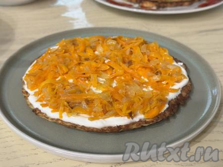 Поверх крема выложить 1/3 часть обжаренных овощей, аккуратно разровнять.