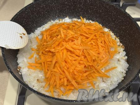 К обжаренному луку добавить морковку, натёртую на крупной тёрке, перемешать, посолить по вкусу, жарить минут 10-12 (до мягкости морковки), время от времени перемешивая.
