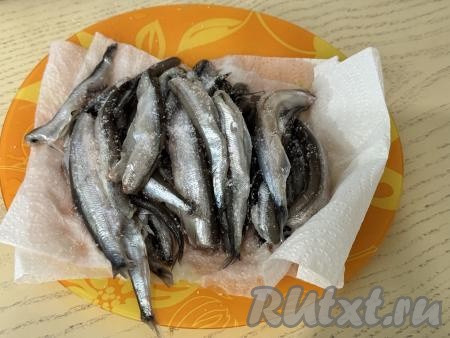 Миску с тестом, накрыв пищевой плёнкой (или полотенцем), оставить в тёплом месте на 1 час (до увеличения теста в объёме в 2-3 раза). Пока дрожжевое тесто подходит, можно заняться рыбой. Мойву нужно очистить от головы и внутренностей, удалить хребет и плавники. Хорошо промыть рыбу и обсушить, выложив на бумажные полотенца. Посолить мойву по вкусу.