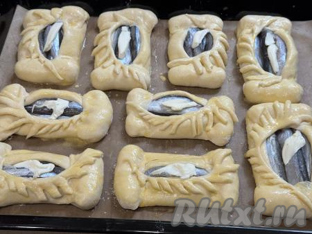 В центр каждого пирожка поверх рыбы выложить грамм 10 сливочного масла. Поставить противень с открытыми пирожками с мойвой в духовку, разогретую до 200 градусов.