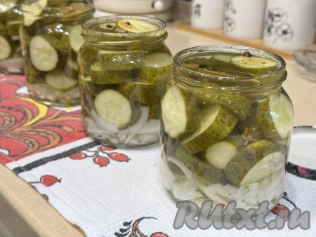 Залить огурцы с луком кипящим маринадом, полностью покрывая овощи. Сразу закатать (или закрутить) банки прокипячёнными крышками.