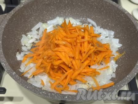 К обжаренному луку выложить морковку, натёртую на крупной тёрке, перемешать, обжаривать овощи минут 5-6 (до мягкости моркови), не забывая иногда перемешивать.&nbsp;