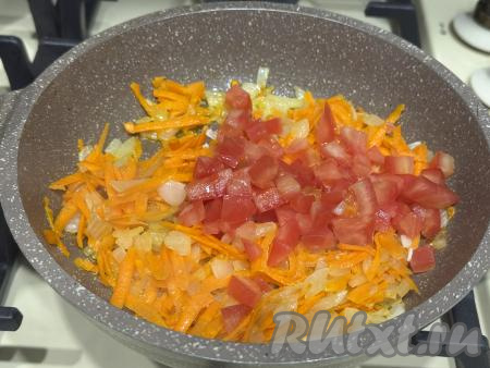 К обжаренным овощам выложить мелко нарезанный помидор (при желании предварительно с помидора можно снять кожицу), перемешать.&nbsp;