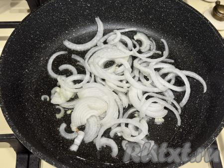 Лук, чеснок и морковь почистить. Кабачок для этого блюда нужно брать молодой, то есть с мелкими семечками и тонкой кожурой. Тонкую кожуру с кабачка можно не срезать. Кабачок и свежую зелень (у меня - кинза, можно взять петрушку) вымыть.&nbsp;В сковороду влить растительное масло, разогреть, выложить лук, нарезанный на полукольца. Обжарить лук до прозрачности (в течение 5-6 минут), иногда помешивая, на среднем огне.&nbsp;