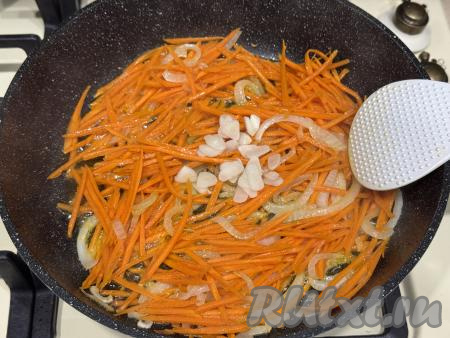 Обжарить овощи до мягкости морковки (в течение минут 7), время от времени помешивая. Чеснок мелко нарезать, добавить в сковороду с обжаренными овощами, перемешать.&nbsp;