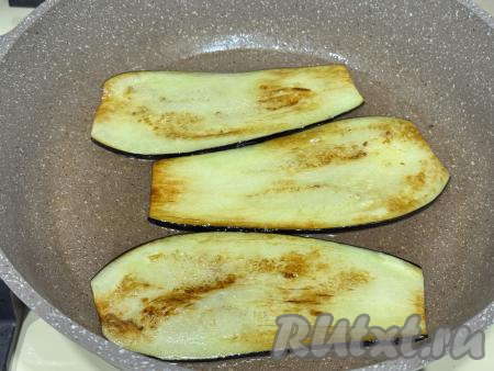 Жарить баклажаны с двух сторон до золотистого цвета на среднем огне. Баклажаны должны стать мягкими, но при этом ещё держать форму. Готовые жареные баклажаны выкладывать со сковороды на бумажные полотенца, чтобы убрать лишнее масло. Постепенно пожарить все полоски баклажана, дать остыть.