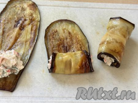 Завернуть полоску баклажана в рулетик, начиная со стороны с начинкой.