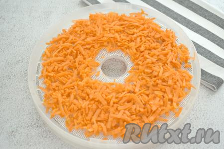 Поддоны для сушилки застилаем специальными силиконовыми сетчатыми ковриками (или силиконизированным пергаментом, он продаётся в любом продуктовом магазине). Натёртую морковку раскладываем нетолстым слоем на поддонах. Вся морковка у меня разместилась на трёх поддонах диаметром 24 сантиметра.