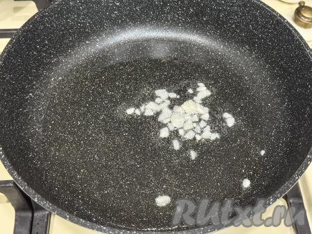 В сковороду влить растительное масло, разогреть, выложить очищенные и мелко нарезанные зубчики чеснока, обжарить на среднем огне 1 минуту, периодически перемешивая.&nbsp;