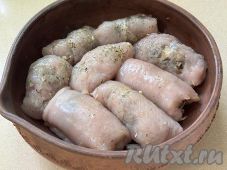 Постепенно сформировать все 8 рулетиков из куриного филе с начинкой из грибов и сыра, выложить их плотно друг к другу в жаропрочную форму. На дно формы влить 50 миллилитров воды. Отправить форму в духовку, разогретую до 200 градусов.
