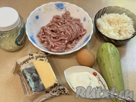 Подготовить продукты для приготовления запеканки из кабачков с фаршем и рисом в духовке.  Фарш можно взять любой (у меня - из свинины). Рис промыть водой, выложить в кастрюлю с достаточно большим количеством кипящей воды, перемешать и отварить до готовности (в течение минут 20-25 с момента закипания воды), затем откинуть на сито, дать остыть. Можно использовать и грамм 200 варёного риса, оставшегося с обеда или ужина. Кабачок вымыть. Если у кабачка толстая кожура, её нужно срезать, крупные семечки нужно обязательно удалить. Я взяла кабачок с тонкой шкуркой и мелкими семечками, поэтому кожуру срезать не стала, просто обрезала у вымытого кабачка кончики с двух сторон.