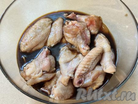 Тщательно перемешать куриные крылышки, покрывая их мёдом и соевым соусом со всех сторон. Оставить крылья мариноваться&nbsp;минут на 30-40. В течение этого времени 2-3 раза крылышки можно перемешать, чтобы они равномерно пропитались маринадом. Соевый соус достаточно солёный, поэтому соль можно не добавлять.