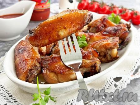 Форму с готовыми куриными крыльями достать из духовки. Разложить крылышки по тарелкам и, дополнив гарниром, в горячем виде подать к столу. Благодаря тому, что крылья и мариновались, и запекались&nbsp;в соевом соусе с мёдом, они получились сочными, вкусными,&nbsp;глазированными. Отличное мясное блюдо для семейного обеда или ужина, попробуйте!