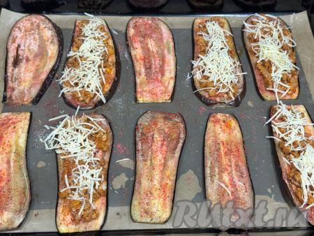 Сыр натереть на мелкой тёрке. Равномерно присыпать полоски баклажана с фаршем половиной натёртого сыра.&nbsp;