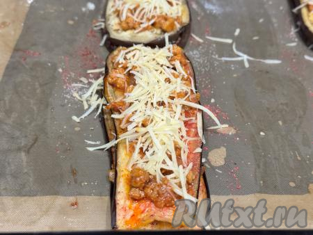 Поверх полосок баклажана равномерно распределить оставшийся жареный фарш и оставшийся натёртый сыр. &nbsp;